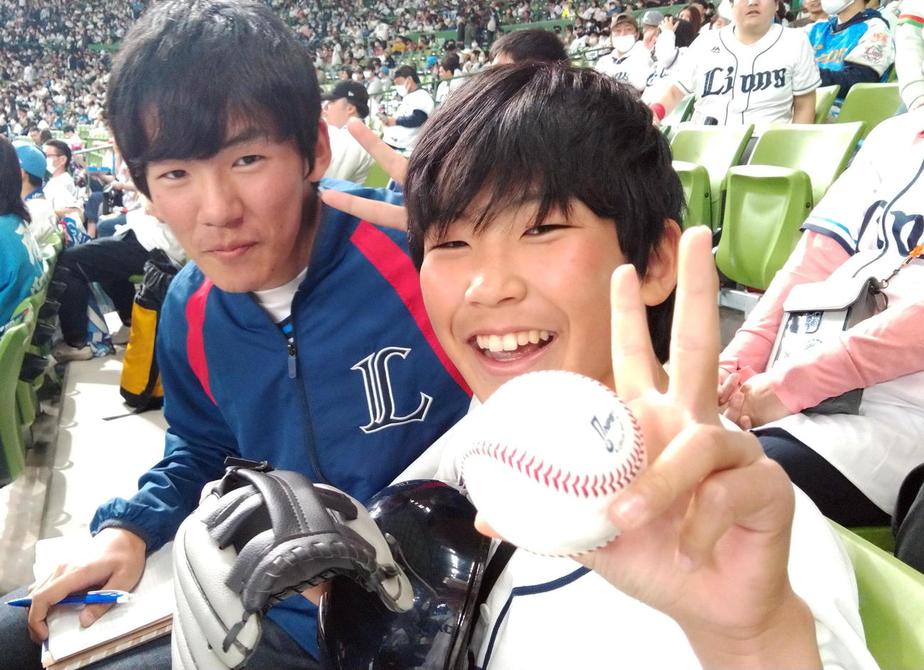 ロッテ池田来のホームランボールを手に笑顔を見せる石川啓太郎くん（右）（石川家提供）