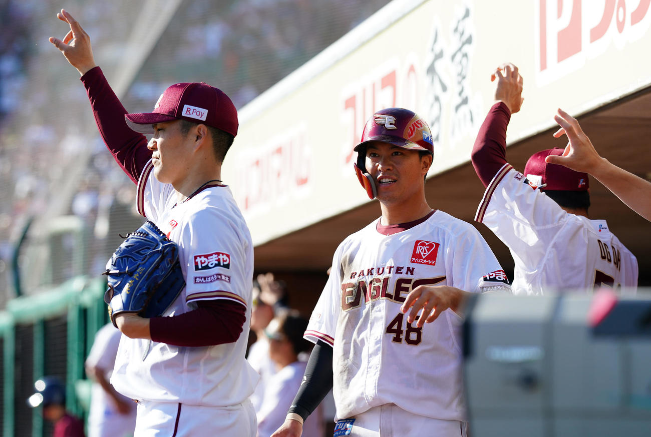 楽天対オリックス　6回表楽天1死一、三塁、浅村の適時打で生還し則本（左）らナインとタッチを交わす渡辺佳（撮影・垰建太）