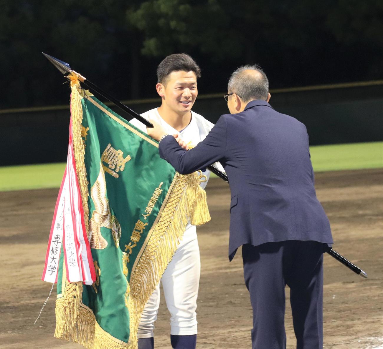 優勝旗を受け取る東洋大の主将・水谷（撮影・星夏穂）