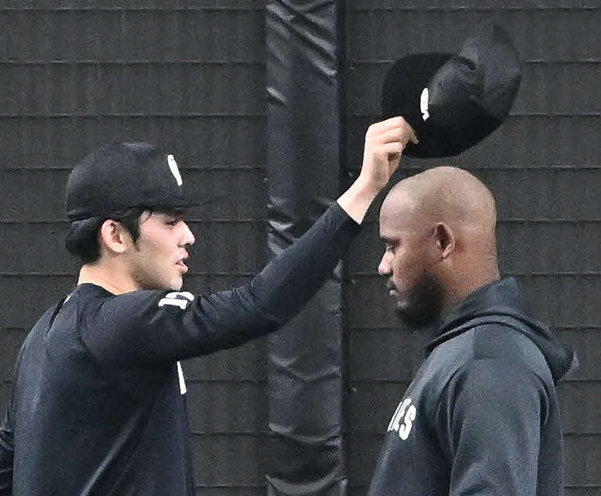 試合前練習でロッテ佐々木朗（左）はメルセデスの帽子を取る（撮影・滝沢徹郎）