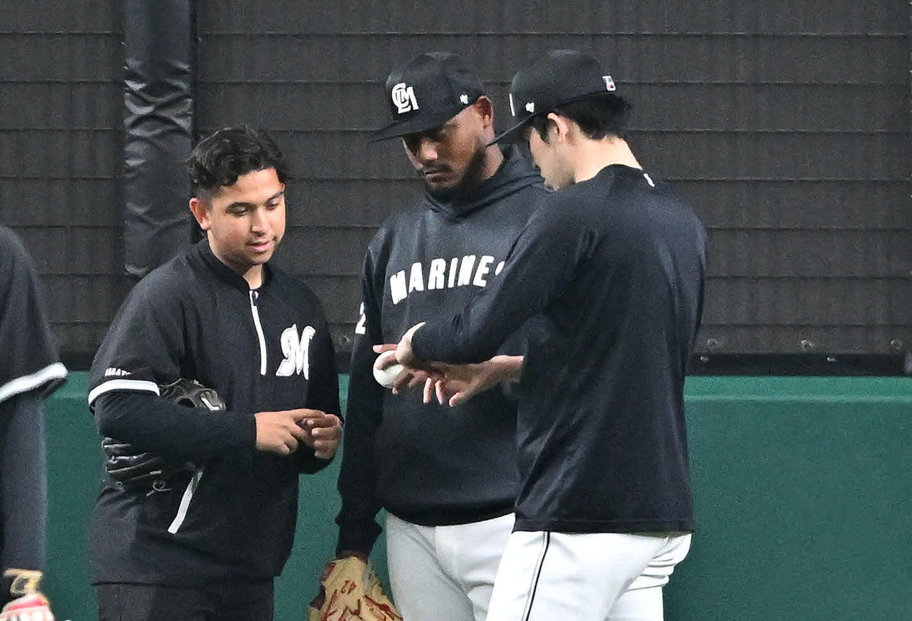 西武対ロッテ　試合前練習でロッテ佐々木朗（右）はメルセデスと握りについて話す（撮影・滝沢徹郎）