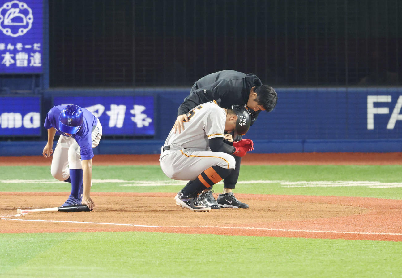 DeNA対巨人　7回表巨人1死二塁、死球を受け、うずくまる岡本和（中央）（撮影・宮地輝）