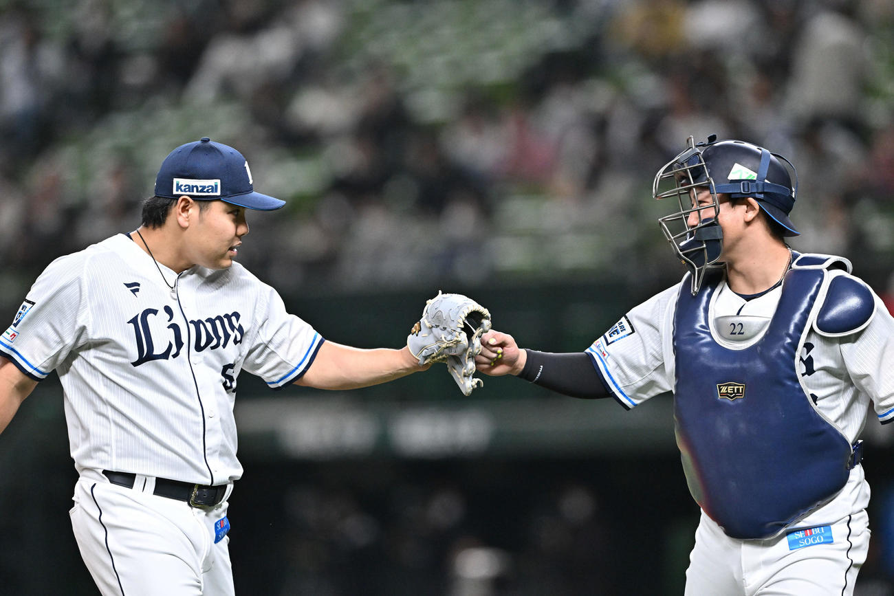 西武対ロッテ　1回表を投げ終えた西武先発の平良（左）は捕手古賀とタッチをかわす（撮影・滝沢徹郎）