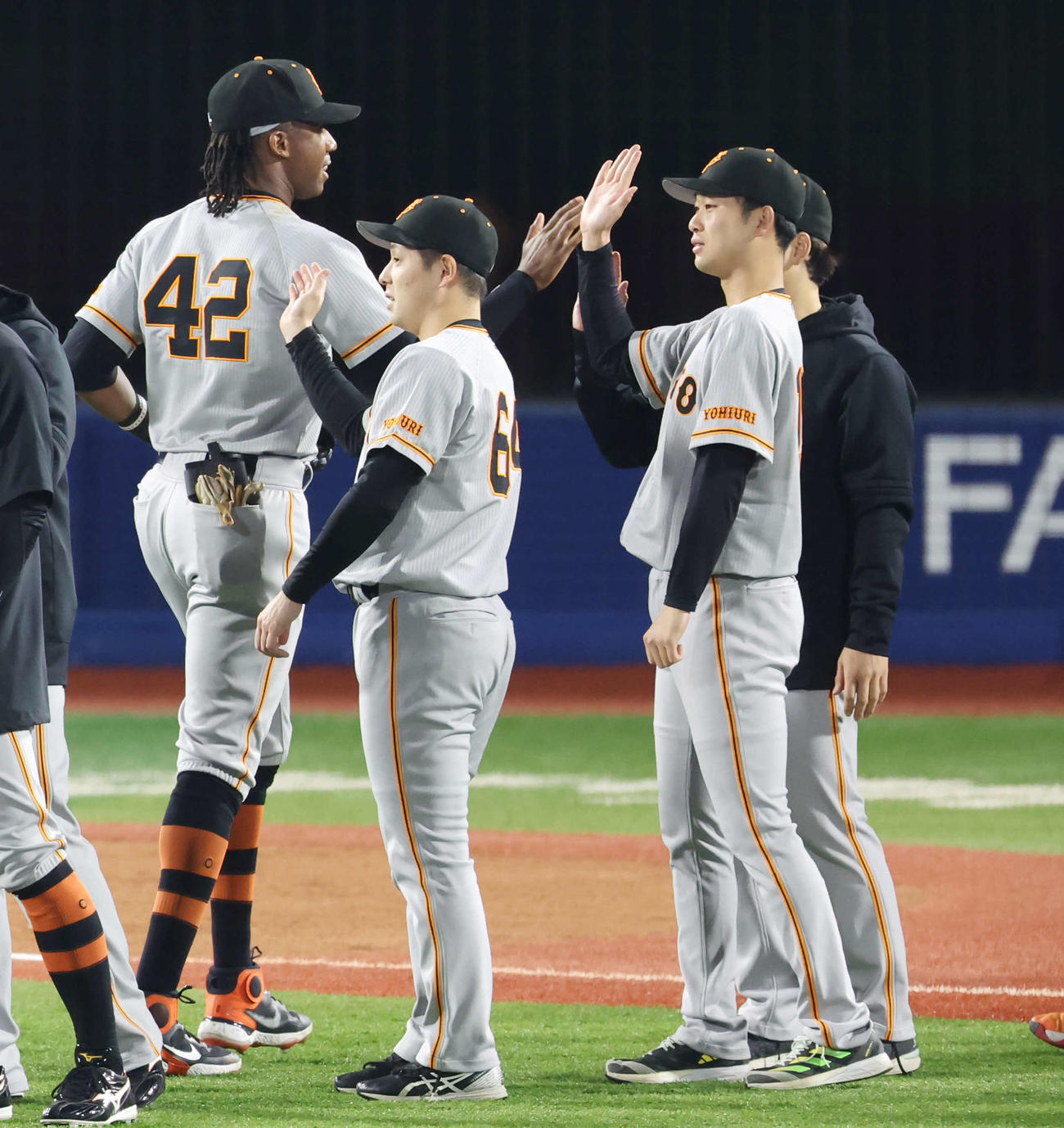 DeNA対巨人　DeNAに勝利し、チームメートとタッチを交わす巨人山崎伊（右）（撮影・宮地輝）