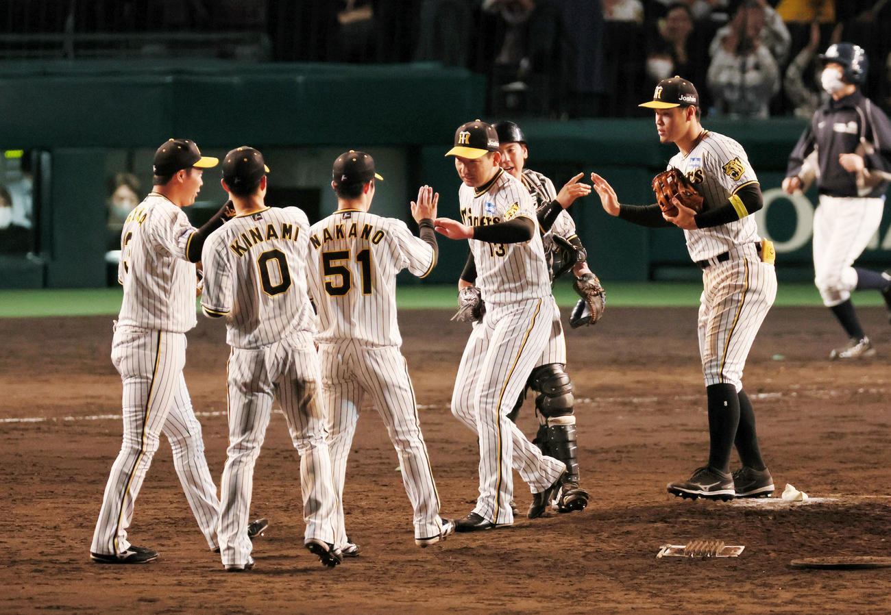 阪神対ヤクルト　9回表に登板し無失点で締めた岩崎はナインとタッチ（撮影・加藤哉）