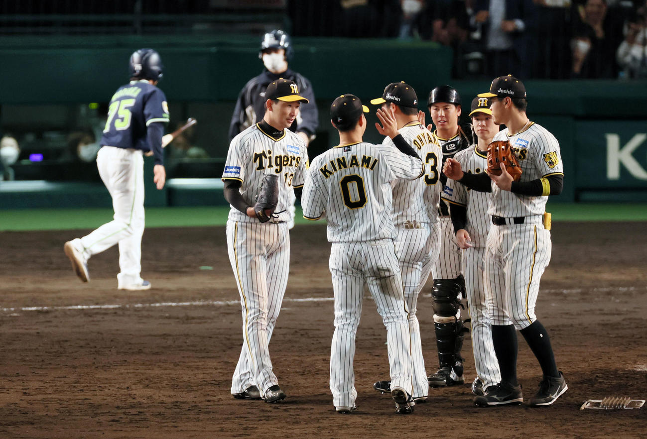 阪神対ヤクルト　9回表に登板し無失点で締めた岩崎はナインとタッチ（撮影・加藤哉）