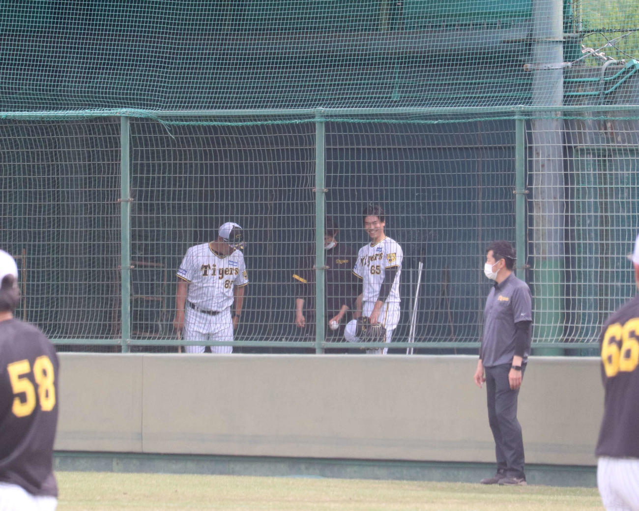 阪神湯浅（右）は降格後4度目となるブルペン投球を終え、福原コーチらと話す（撮影・三宅ひとみ）