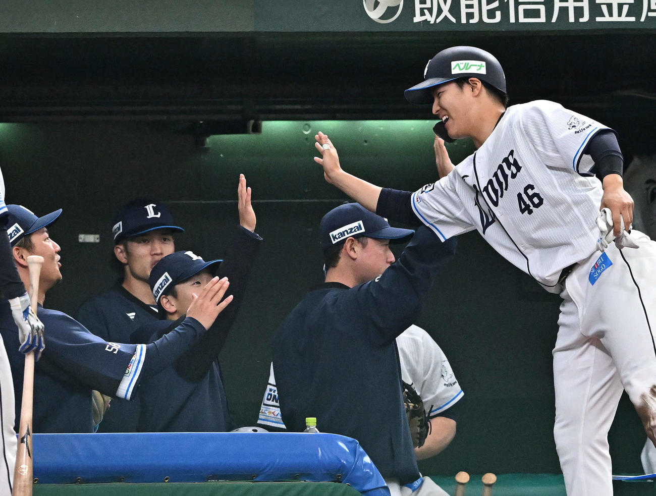 西武対楽天　4回裏に3点適時三塁打を放った西武鈴木（右）はベンチへ戻りチームメートとタッチをかわす（撮影・滝沢徹郎）
