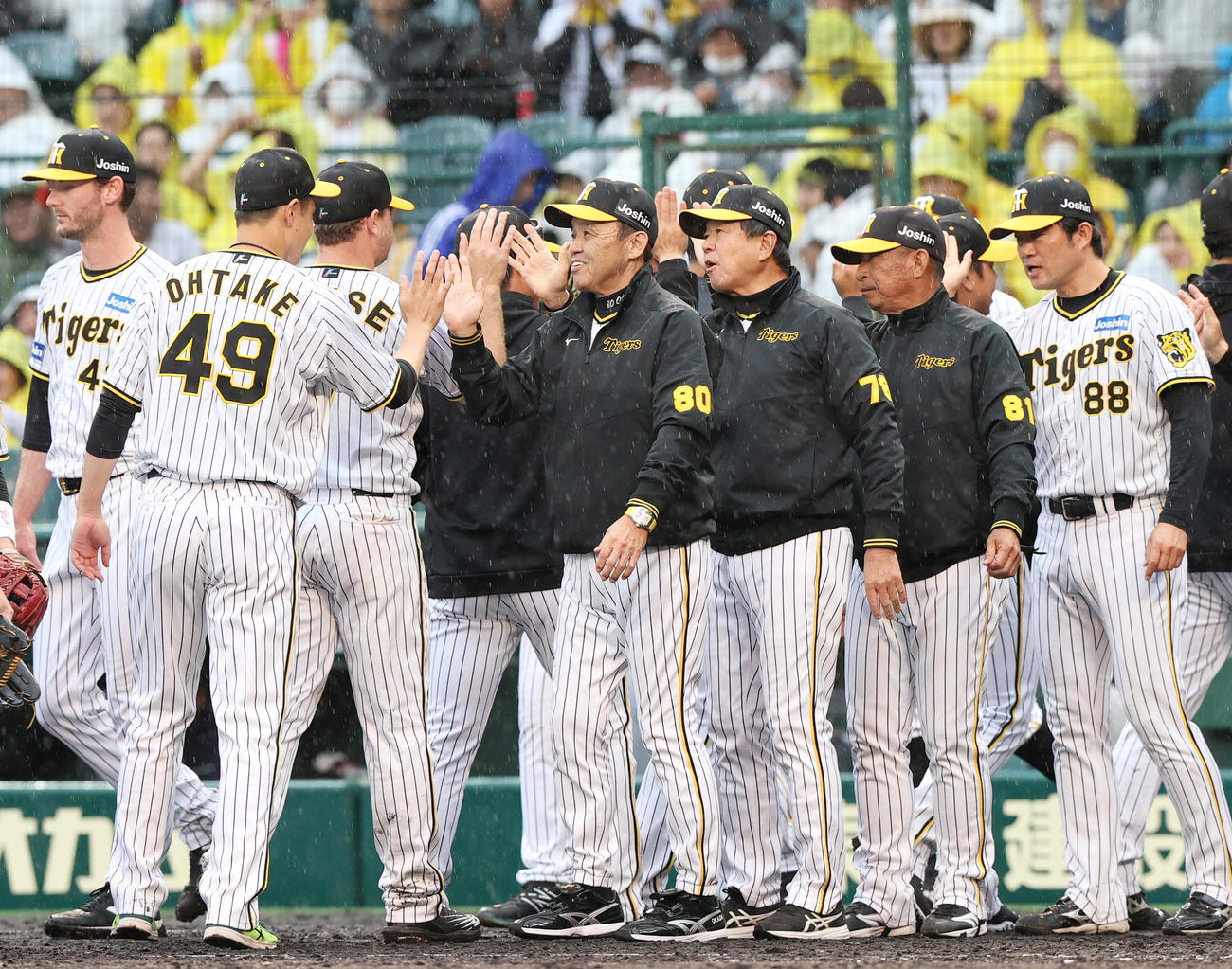 阪神対DeNA　監督通算600勝を挙げた阪神岡田監督（中央）は大竹らナインと笑顔でタッチを交わす（撮影・上山淳一）