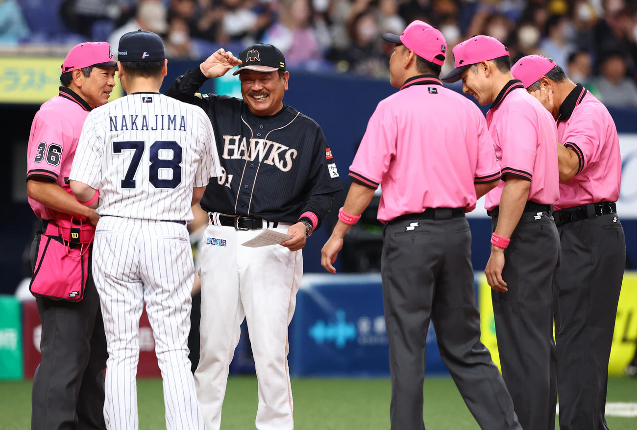 オリックス対ソフトバンク　ピンクのユニホームでメンバー表交換に臨む審判団と笑顔のソフトバンク藤本監督（左から3人目）（撮影・藤尾明華）