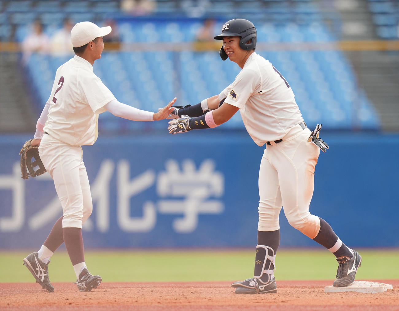 早大対明大　1回裏明大1死一、三塁、先制の左適時二塁打を放ち二塁へ滑り込んだ際、二塁手山県（左）とぶつかり、謝る上田希（撮影・鈴木みどり）