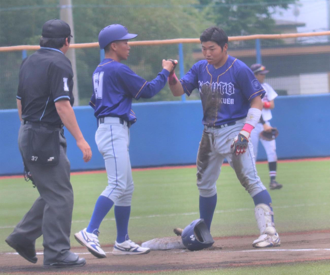 作新学院大対関東学園大　8回関東学園大無死　中越え三塁打を放ちグータッチをする山後（右）（撮影・星夏穂）