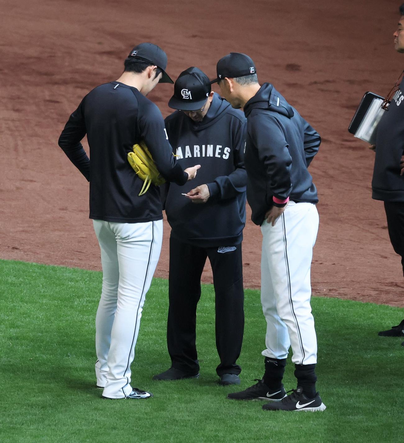 日本ハム対ロッテ　試合前練習中、佐々木朗の指を気にする吉井監督（右）（撮影・黒川智章）