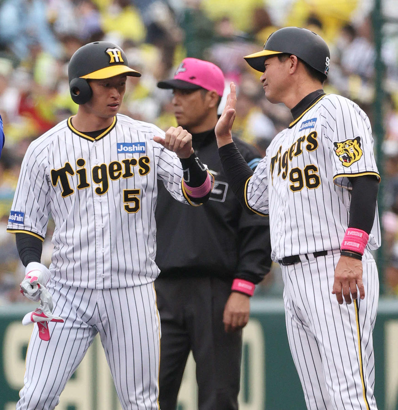 阪神対DeNA 1回裏阪神無死、左前打を放ち筒井外野守備走塁コーチ（右）とタッチをかわす近本（撮影・上山淳一）