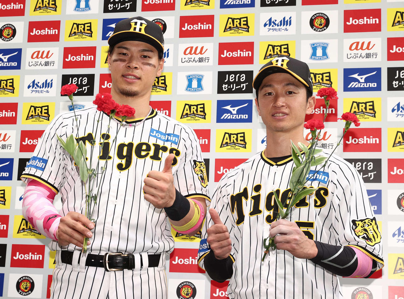 阪神対DeNA　お立ち台でカーネーションを手にサムズアップポーズを見せる佐藤輝（左）と近本（撮影・上田博志）