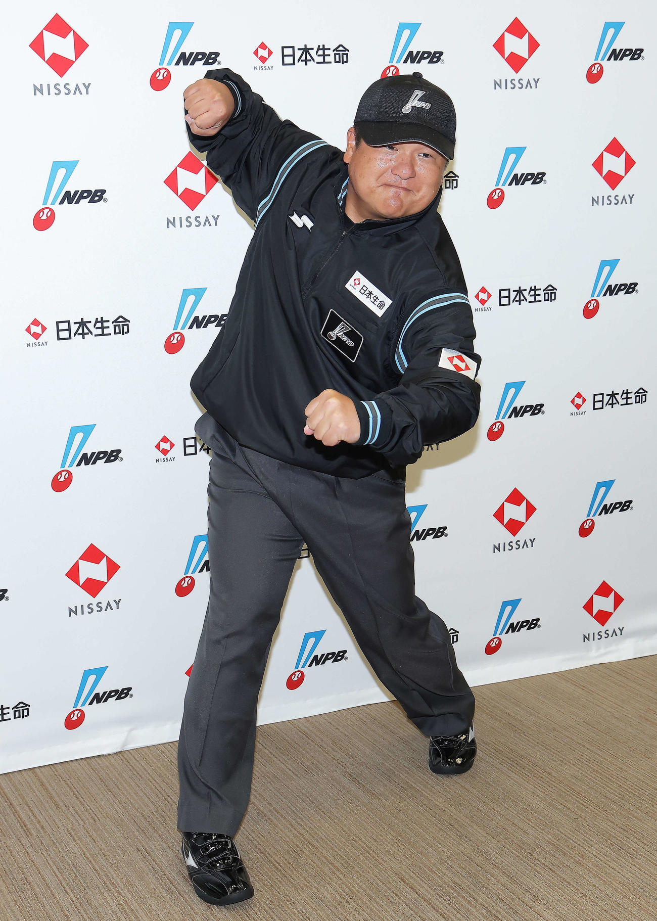 「NPB審判員ユニホーム広告記者発表」でポーズを決め写真に納まる敷田審判員（撮影・河田真司）
