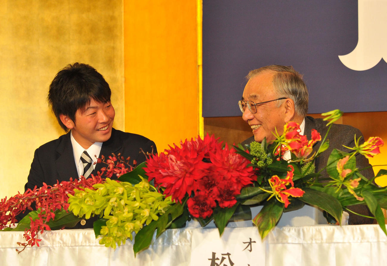 2013年12月9日、広島新入団選手発表　壇上で松田元オーナー（右）と談笑する大瀬良大地