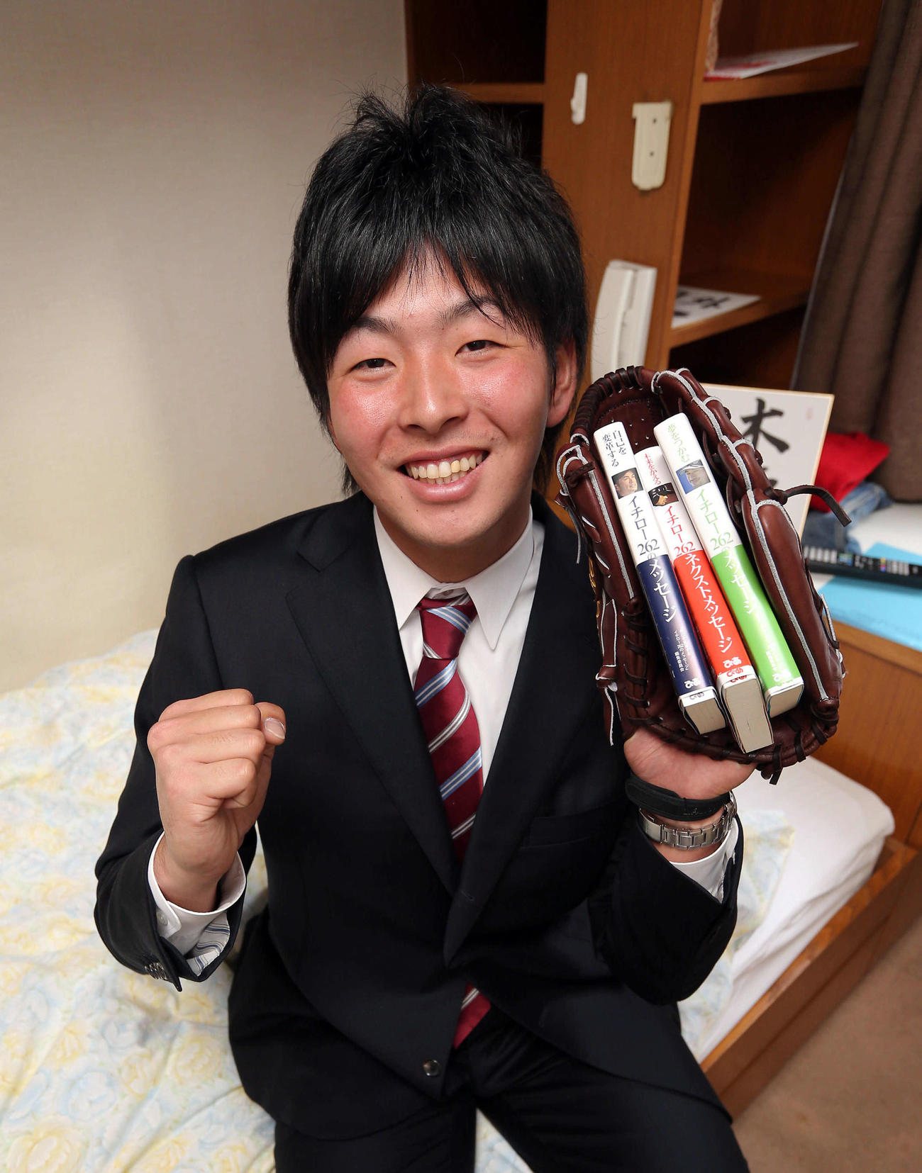 2014年1月、入寮した大瀬良大地はイチローの本を手に笑顔を見せる