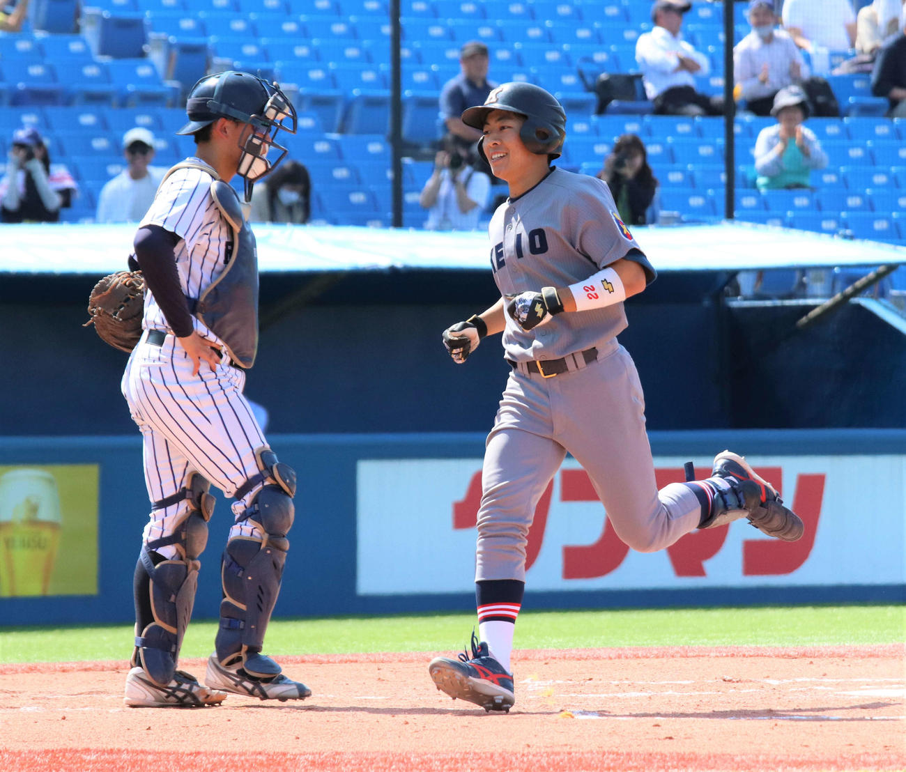 慶大対立大　6回表慶大2死一、二塁、3点本塁打を放ち、生還する斎藤快（右）（撮影・村山玄）