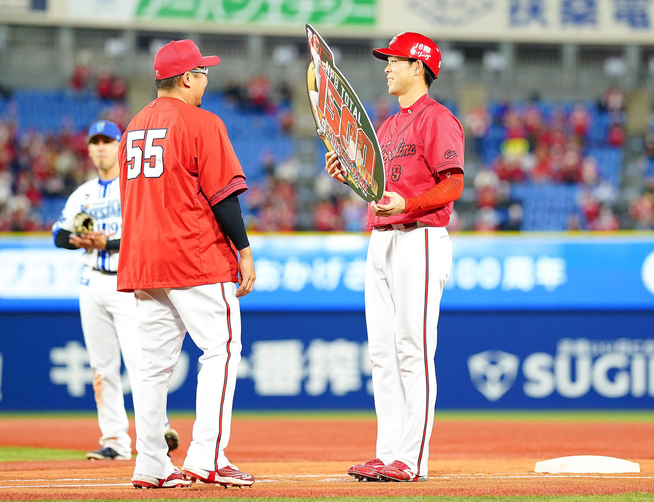 DeNA対広島　4回表広島2死、通算1500安打となる二塁内野安打を放った秋山（右）は松山から記念のボードを渡され笑顔を見せる（撮影・垰建太）