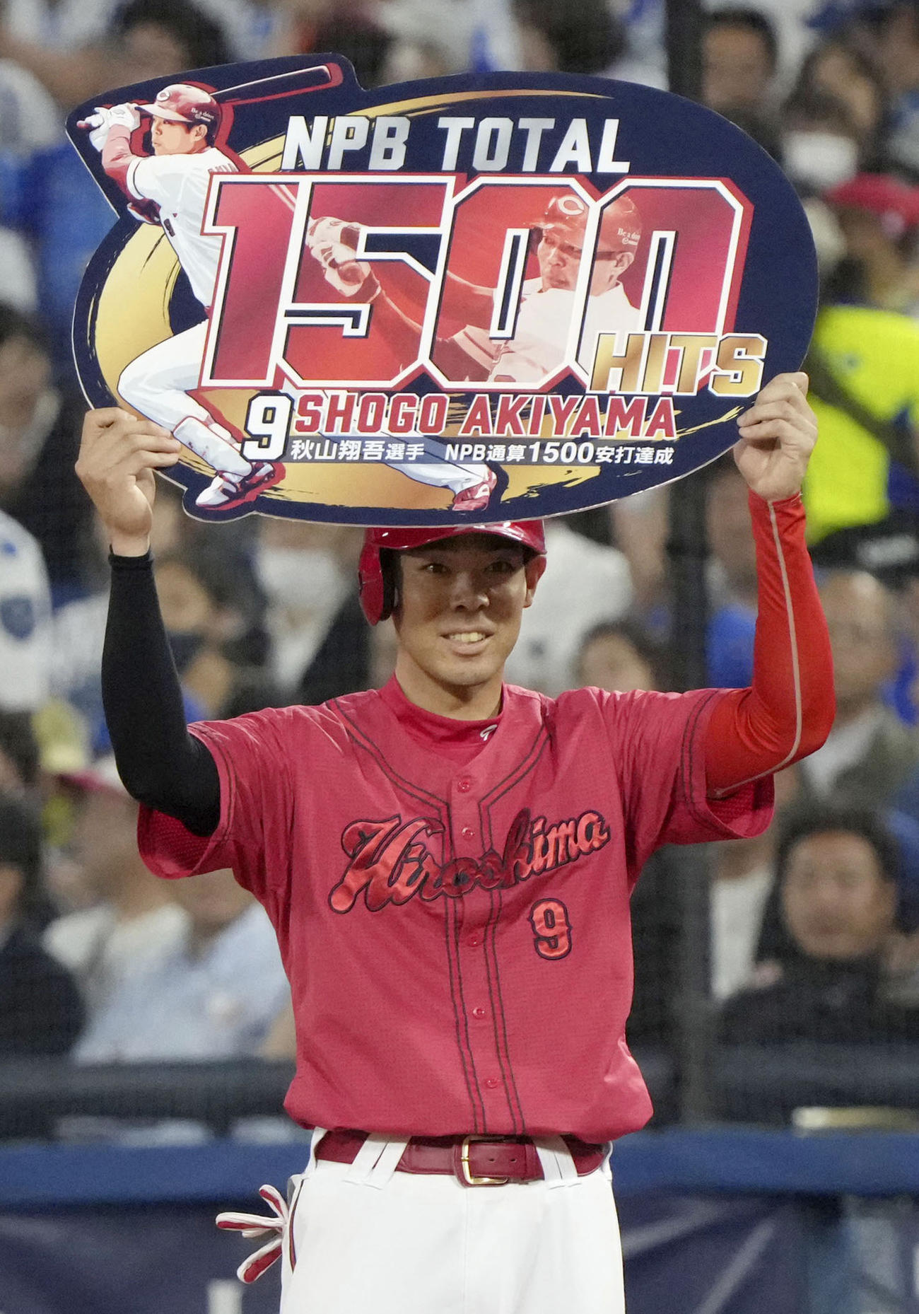 4回、通算1500安打を達成し、記念のボードを掲げる広島・秋山（共同）