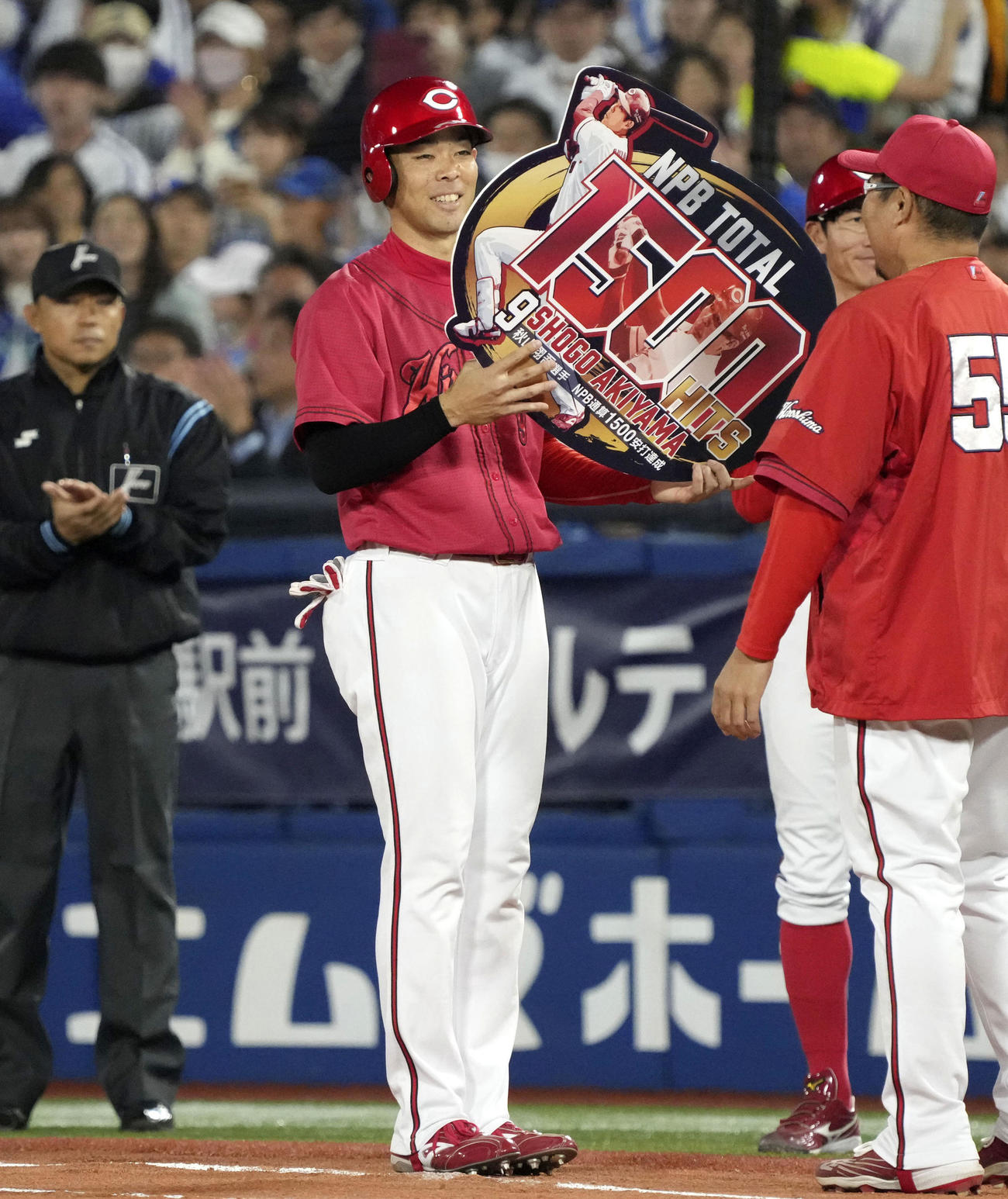 4回、通算1500安打を達成し、記念のボードを手にする広島・秋山（共同）