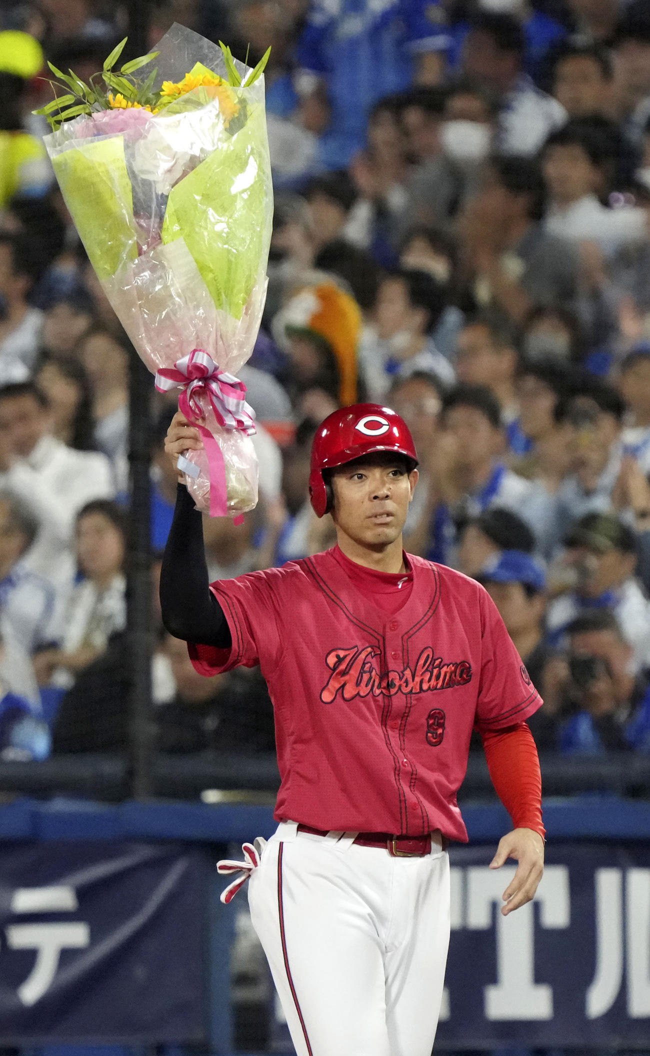 4回、通算1500安打を達成し、花束を掲げる広島・秋山（共同）