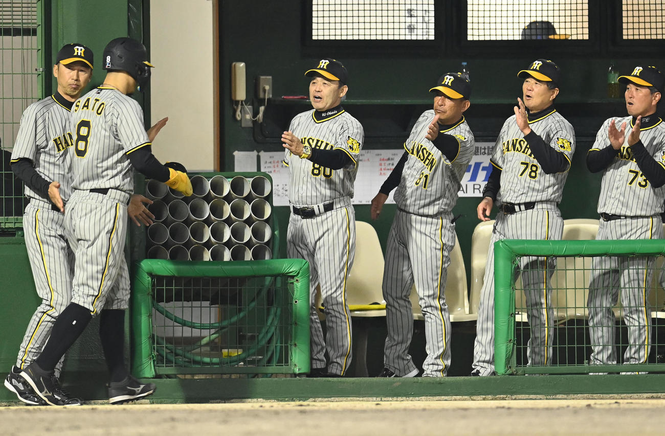 中日対阪神　5回表阪神1死一、三塁、木浪の右前適時打で生還した佐藤輝を迎える岡田監督（左から3人目）ら阪神ナイン（撮影・森本幸一）