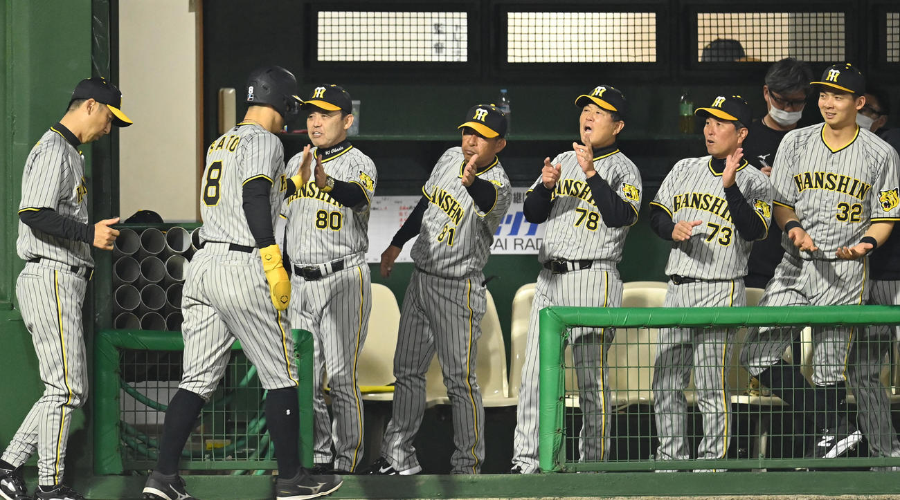 中日対阪神　5回表阪神1死一、三塁、木浪の右前適時打で生還した佐藤輝を迎える岡田監督（左から3人目）ら阪神ナイン（撮影・森本幸一）