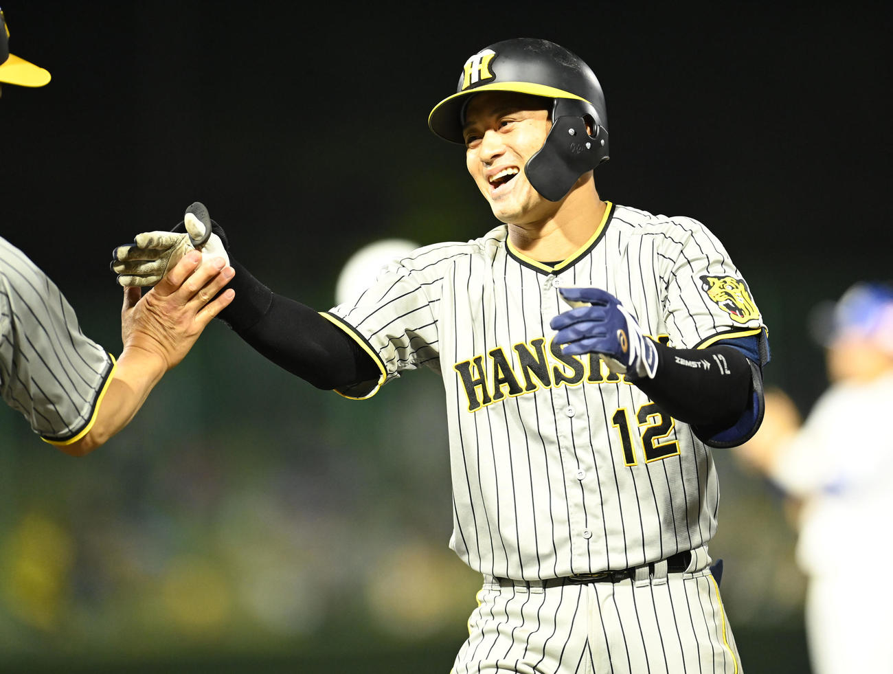中日対阪神　5回表阪神1死二、三塁、坂本は中前適時打を放ち笑顔でタッチ（撮影・森本幸一）