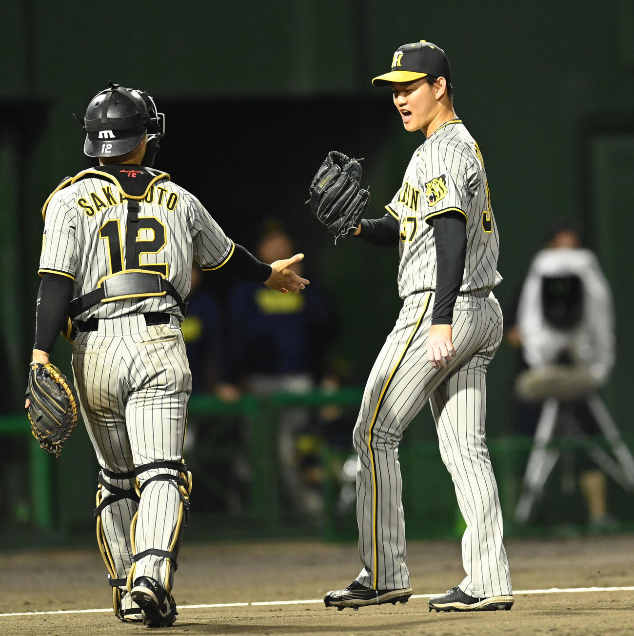 中日対阪神　6回終了、坂本とタッチを交わしベンチへ戻る及川（右）（撮影・森本幸一）