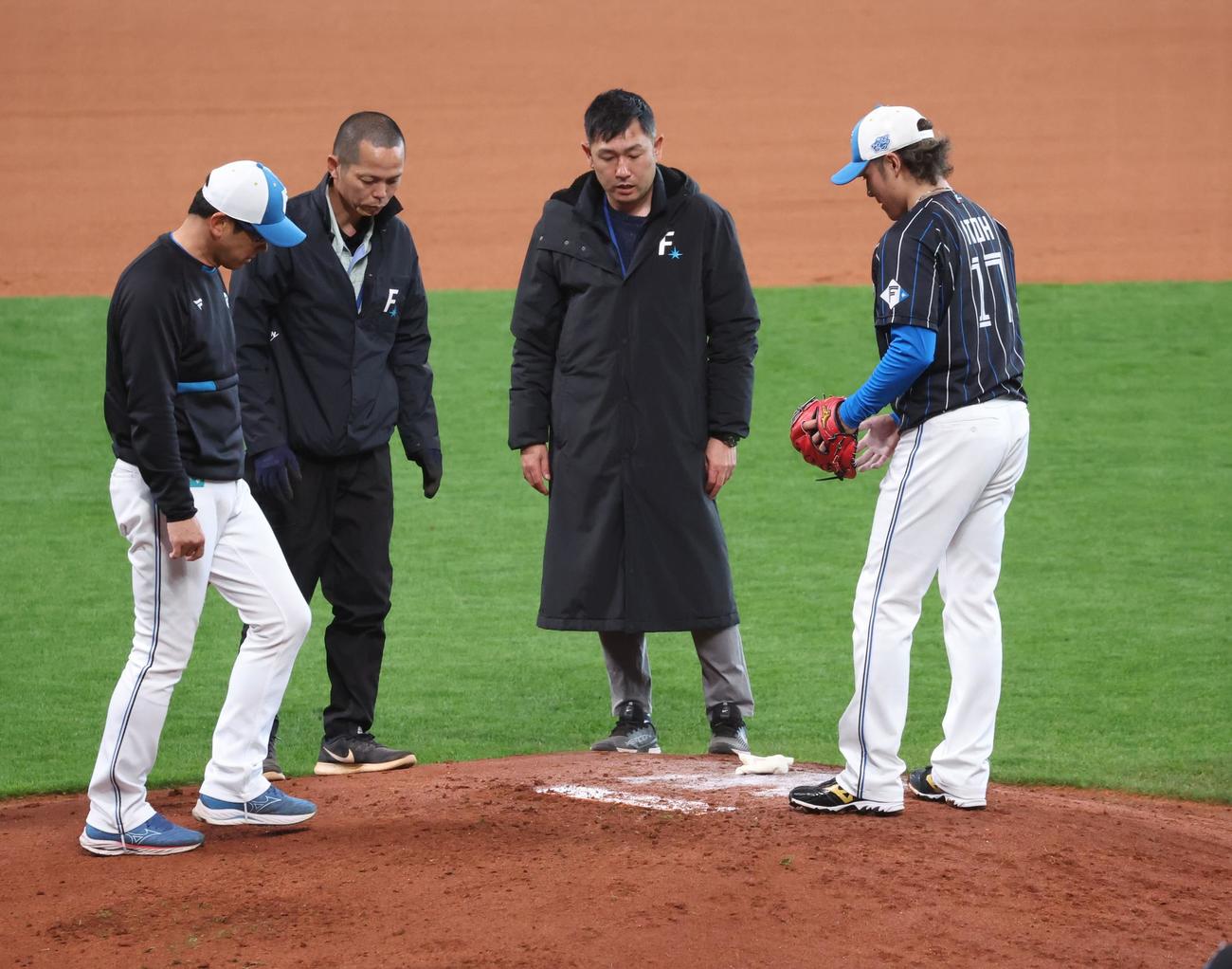 日本ハム対西武　練習中、スタッフとマウンドの調整をする伊藤（右）（撮影・黒川智章）