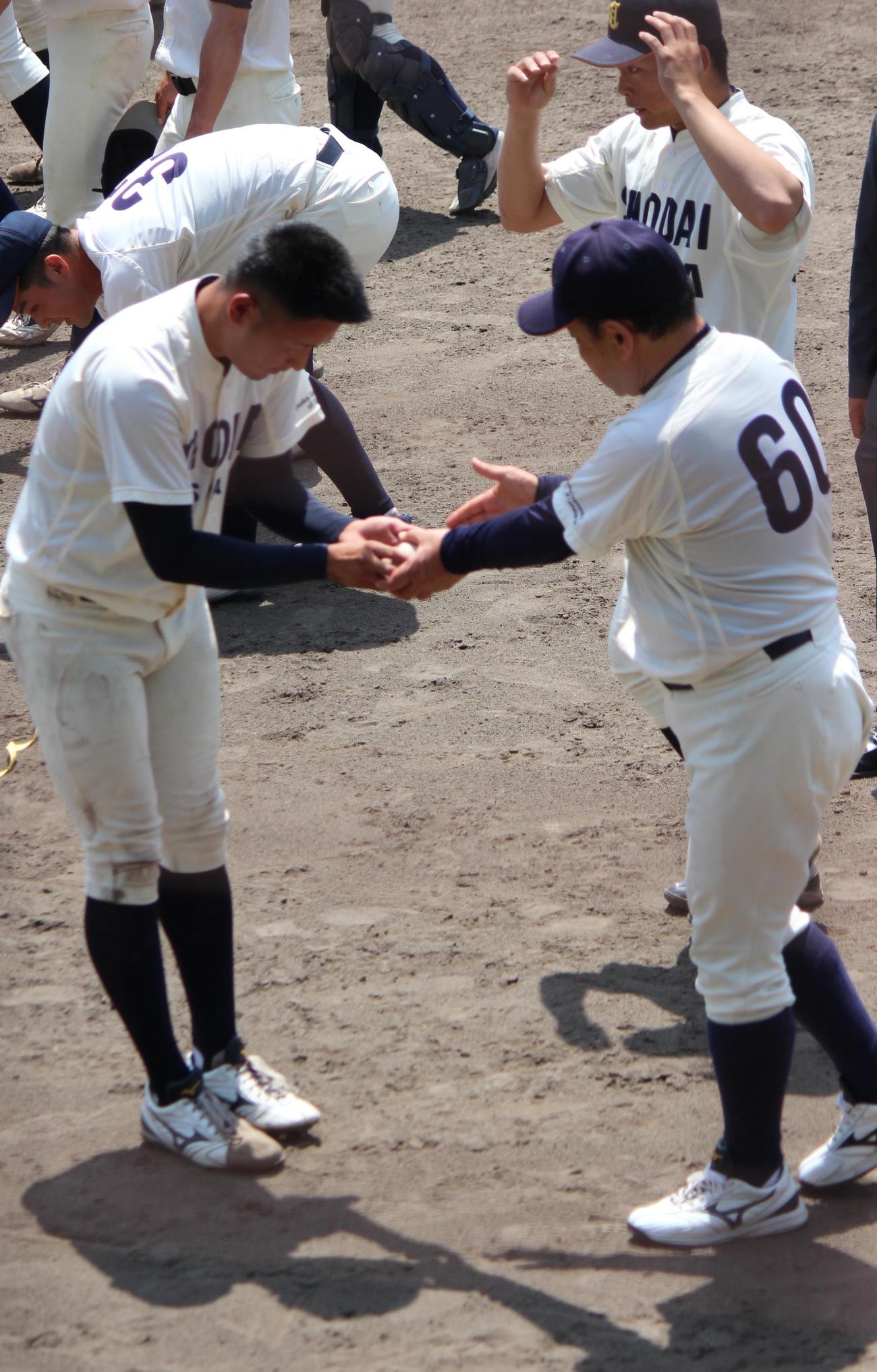 大経大対大商大　ウイニングボールを富山監督（右）に手渡す大商大・上田主将（撮影・柏原誠）