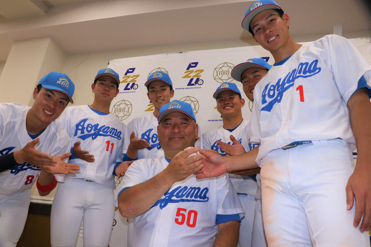 青学大対国学院大　優勝し、青学大・安藤監督（中央）にウイニングボールを手渡す中島主将（右端）ら＝2023年5月17日（撮影・黒須亮）