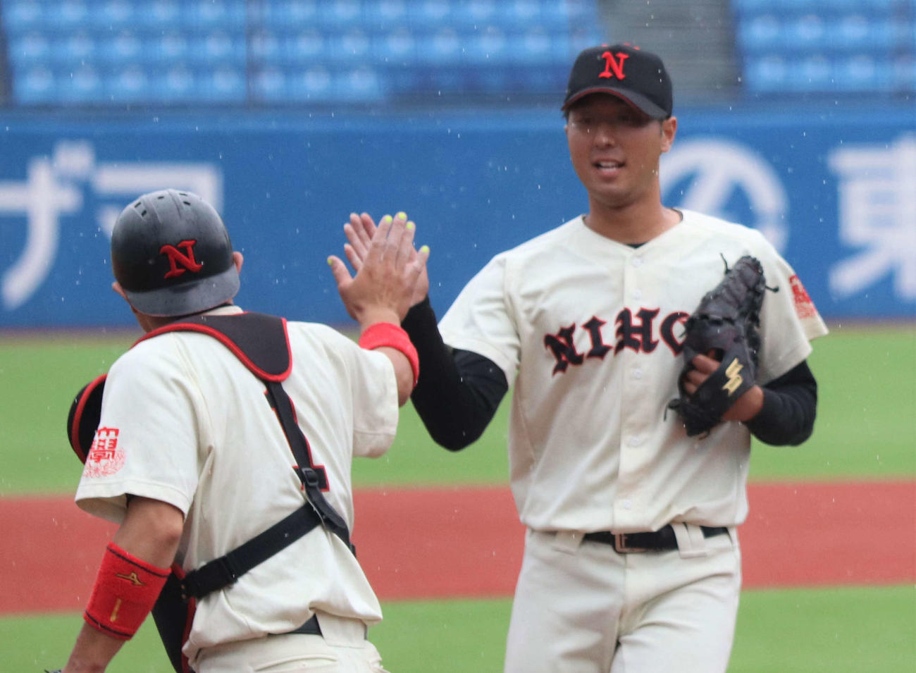 日大対中大　9回から登板し、試合を締めた日大・市川は捕手の友田とハイタッチを交わす（撮影・黒須亮）