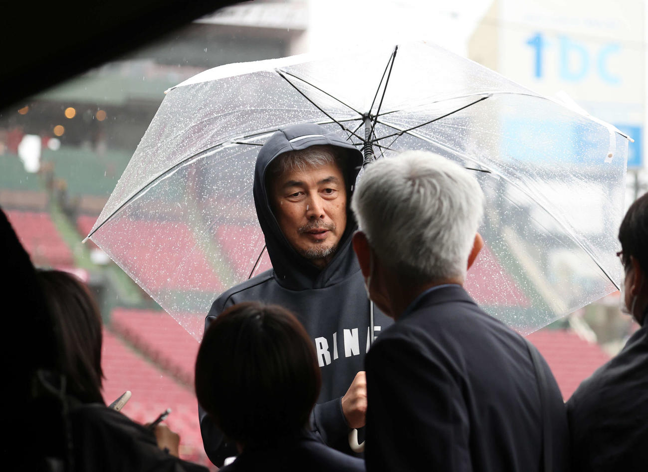 楽天対ロッテ　傘をさして報道陣の質問に答えるロッテ吉井監督（撮影・浅見桂子）