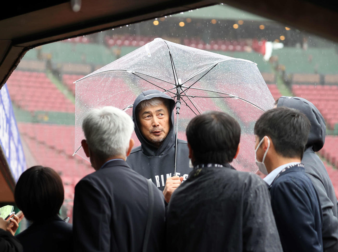 楽天対ロッテ　傘をさして報道陣の質問に答えるロッテ吉井監督（撮影・浅見桂子）