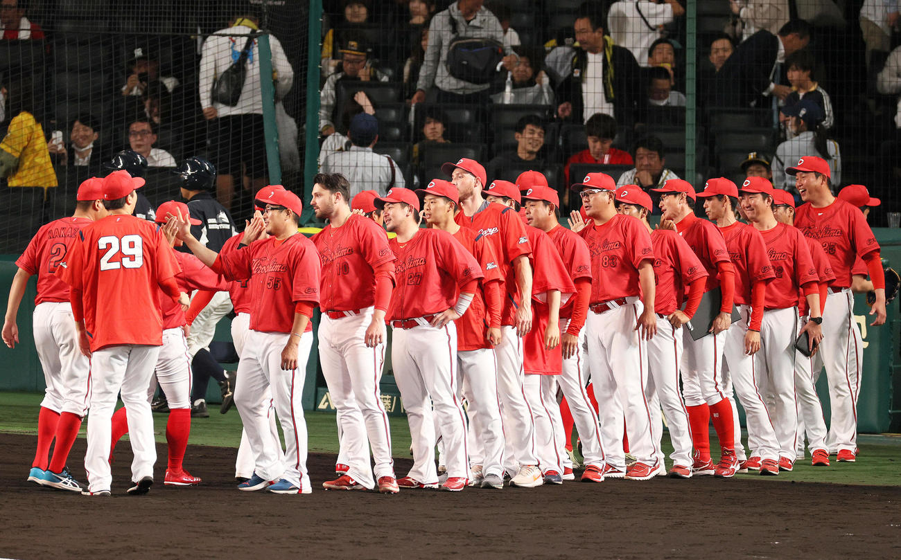 阪神対広島　阪神に勝利し、ベンチ前でナインとタッチする広島新井監督（右）（撮影・上山淳一）