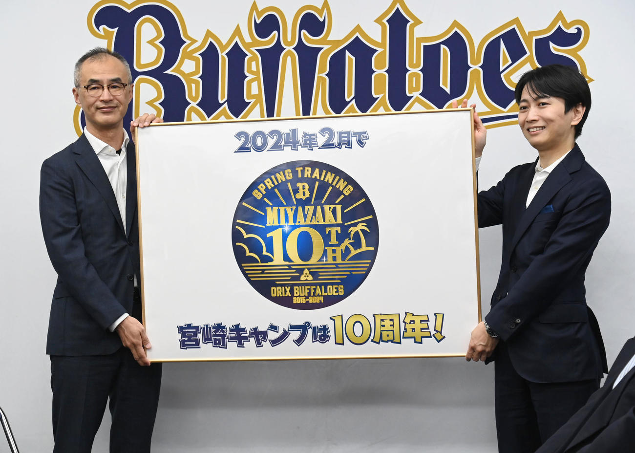 湊通夫球団取締役社長（左）に宮崎キャンプ10周年ロゴを贈呈する宮崎市長津山知憲氏（撮影・石井愛子）