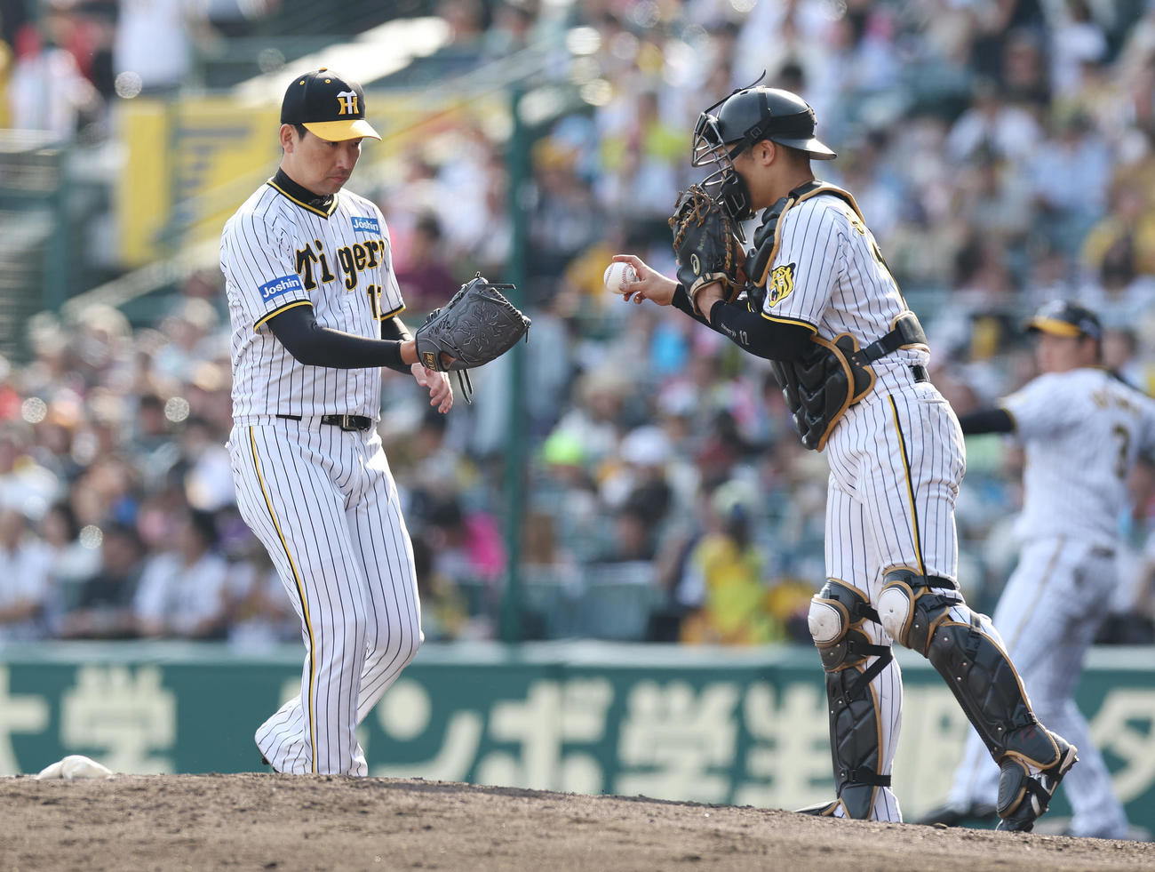 阪神対広島　9回表、阪神坂本（右）からボールを受け取りマウンドに上がる3番手の岩崎（撮影・前田充）