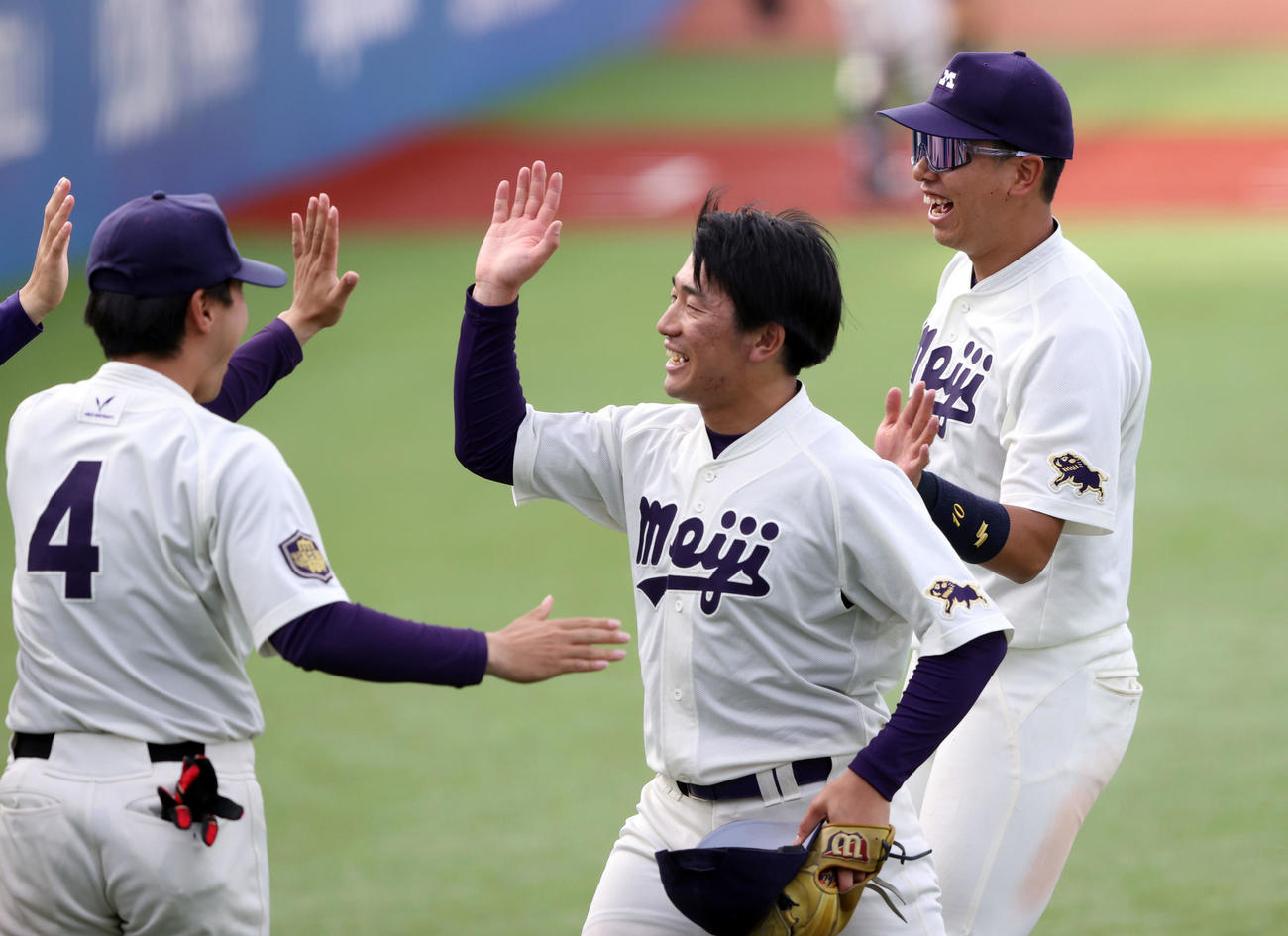 明大対立大　3番手で登板し1死回1安打無失点に抑えたマネジャー兼任の明大石田朗は笑顔でベンチに戻りハイタッチする（中央）（撮影・大野祥一）