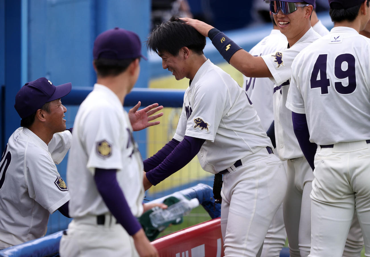 明大対立大　3番手で登板し無失点に抑えた明大石田朗はベンチで田中監督と握手する（撮影・大野祥一）