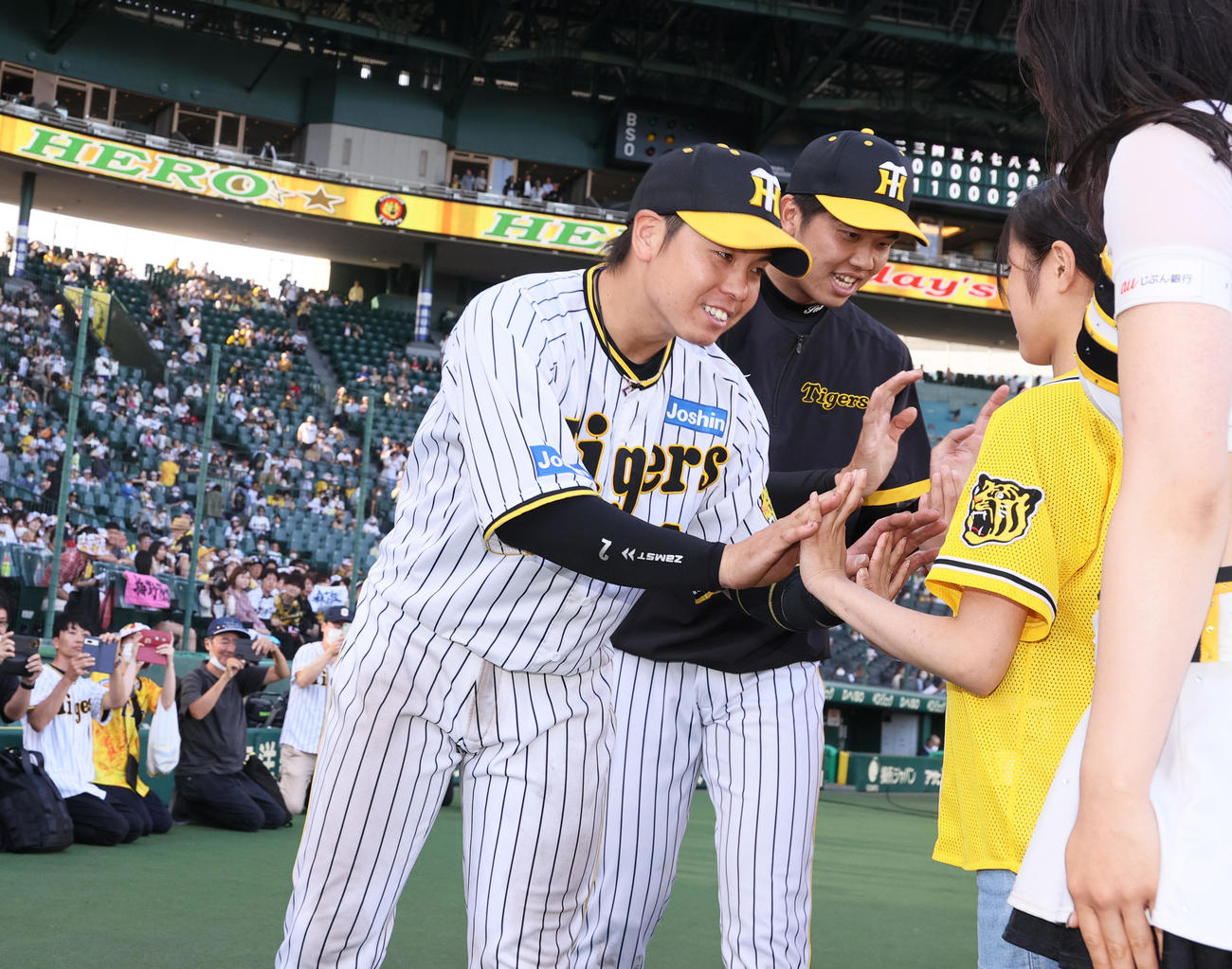 阪神対広島　ヒーローの梅野（左）と才木は子どもとハイタッチする（撮影・上山淳一）