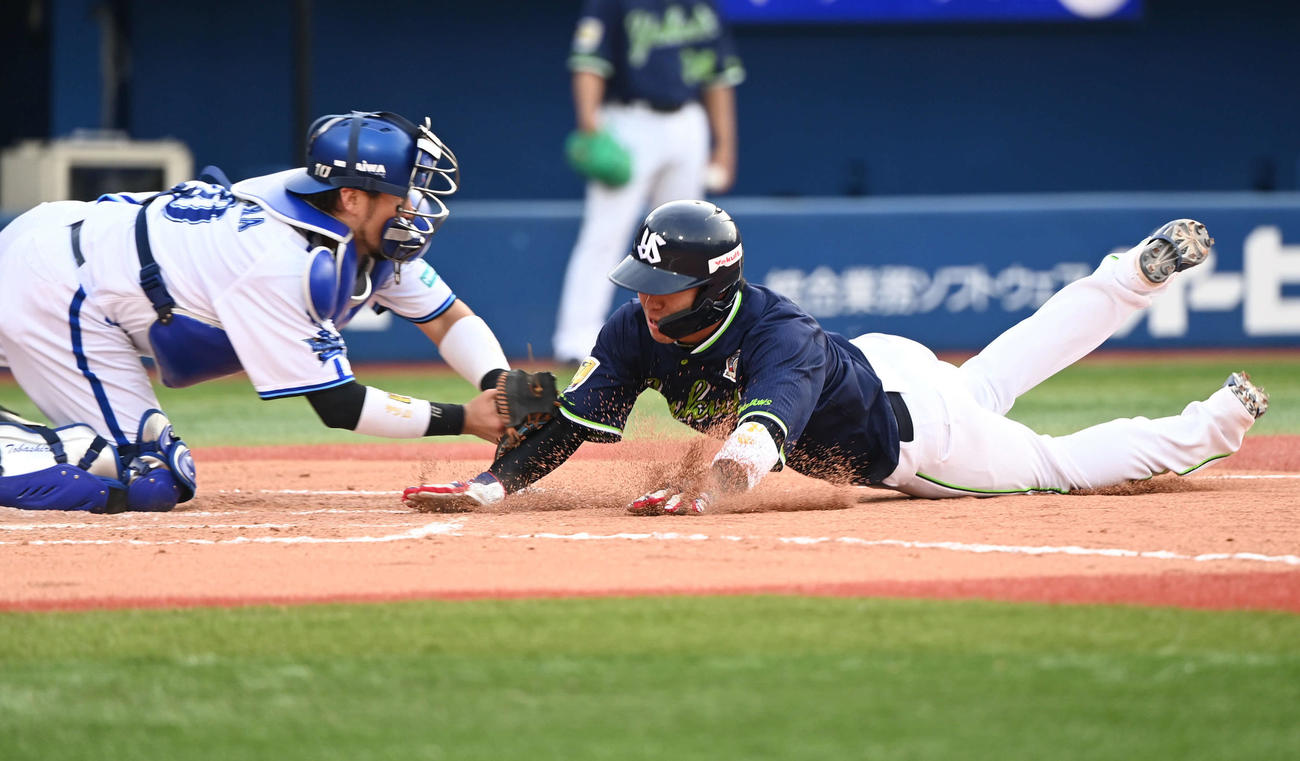 DeNA対ヤクルト　10回表ヤクルト1死満塁、内山の左飛で本塁突入した山田（右）はタッチアウト。捕手戸柱（撮影・山崎安昭）