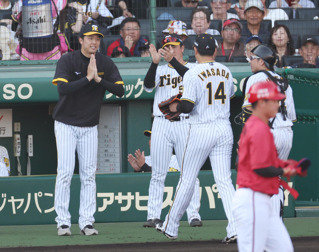 阪神対広島　8回表の広島打線を抑えた阪神岩貞（右から2人目）を手を合わせて迎える才木（左）（撮影・前田充）