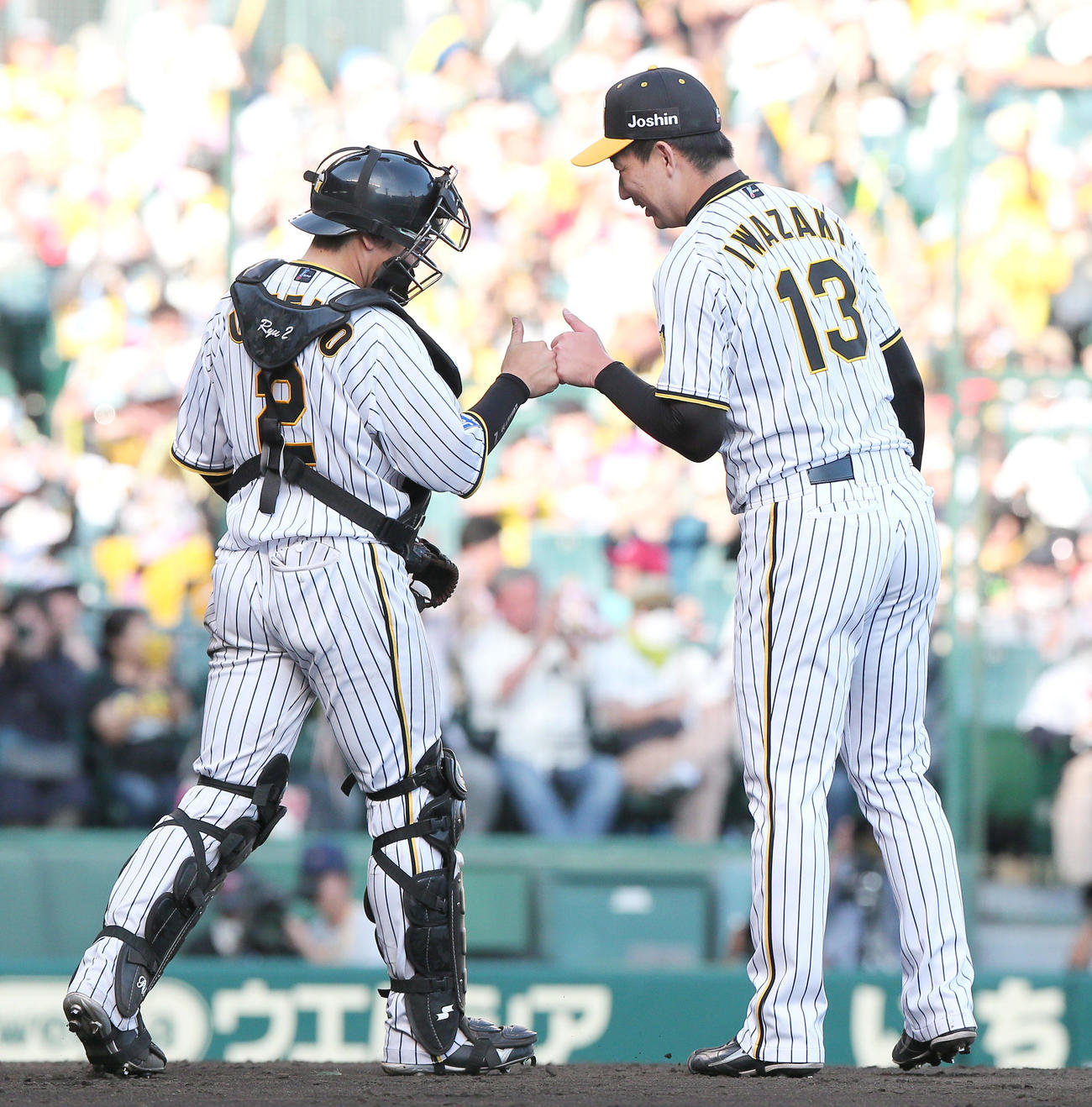 阪神対広島　試合を締めた阪神岩崎（右）は捕手梅野とタッチをかわす（撮影・上山淳一）