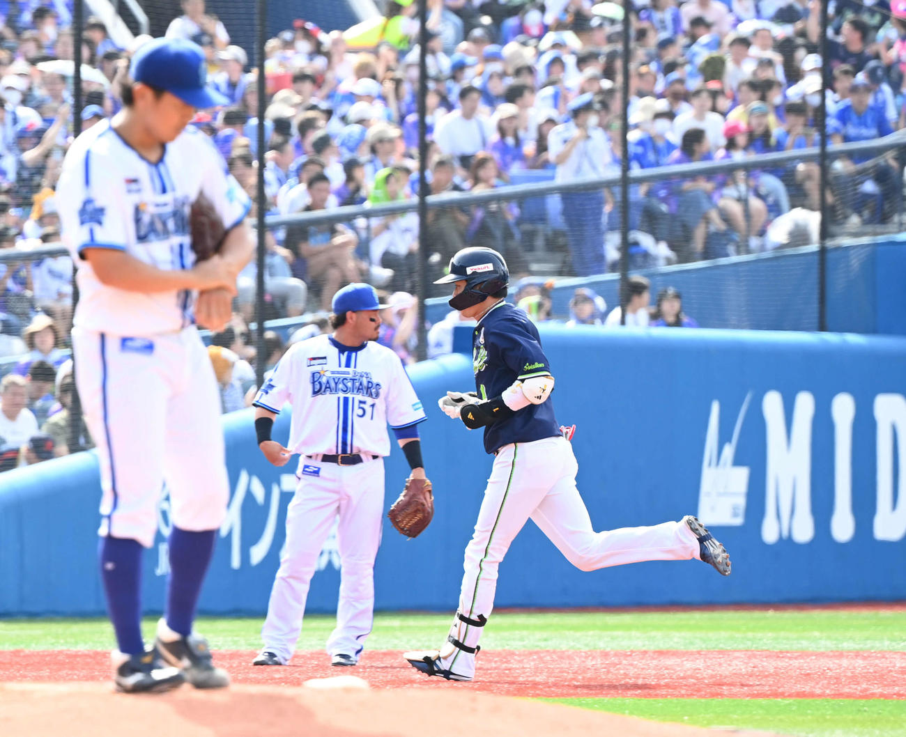 DeNA対ヤクルト　4回表ヤクルト無死、今永（手前）からソロ本塁打を放った山田（右）はゆっくりとダイヤモンドを回る。三塁手宮崎（撮影・山崎安昭）