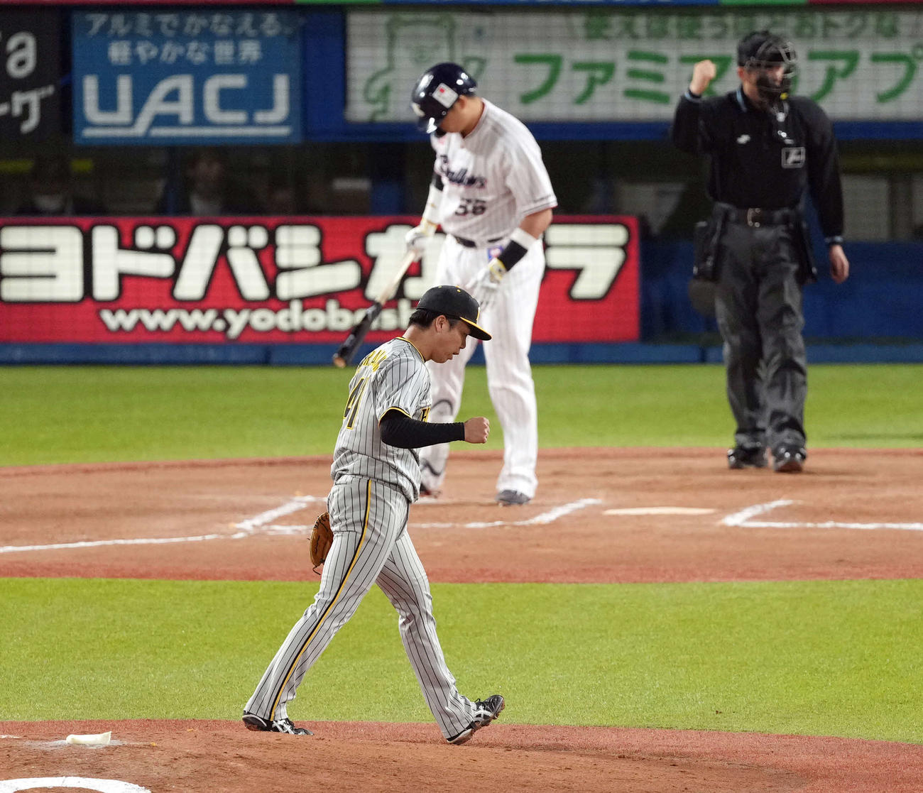 ヤクルト対阪神　6回裏ヤクルト2死、村上（後方）を空振り三振に仕留め、ガッツポーズを決める阪神村上（撮影・狩俣裕三）