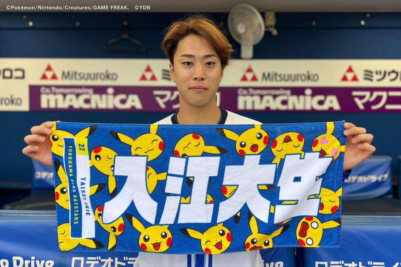 選手名入りのオリジナルのピカチュウタオルを笑顔で手にするDeNA入江（球団提供）