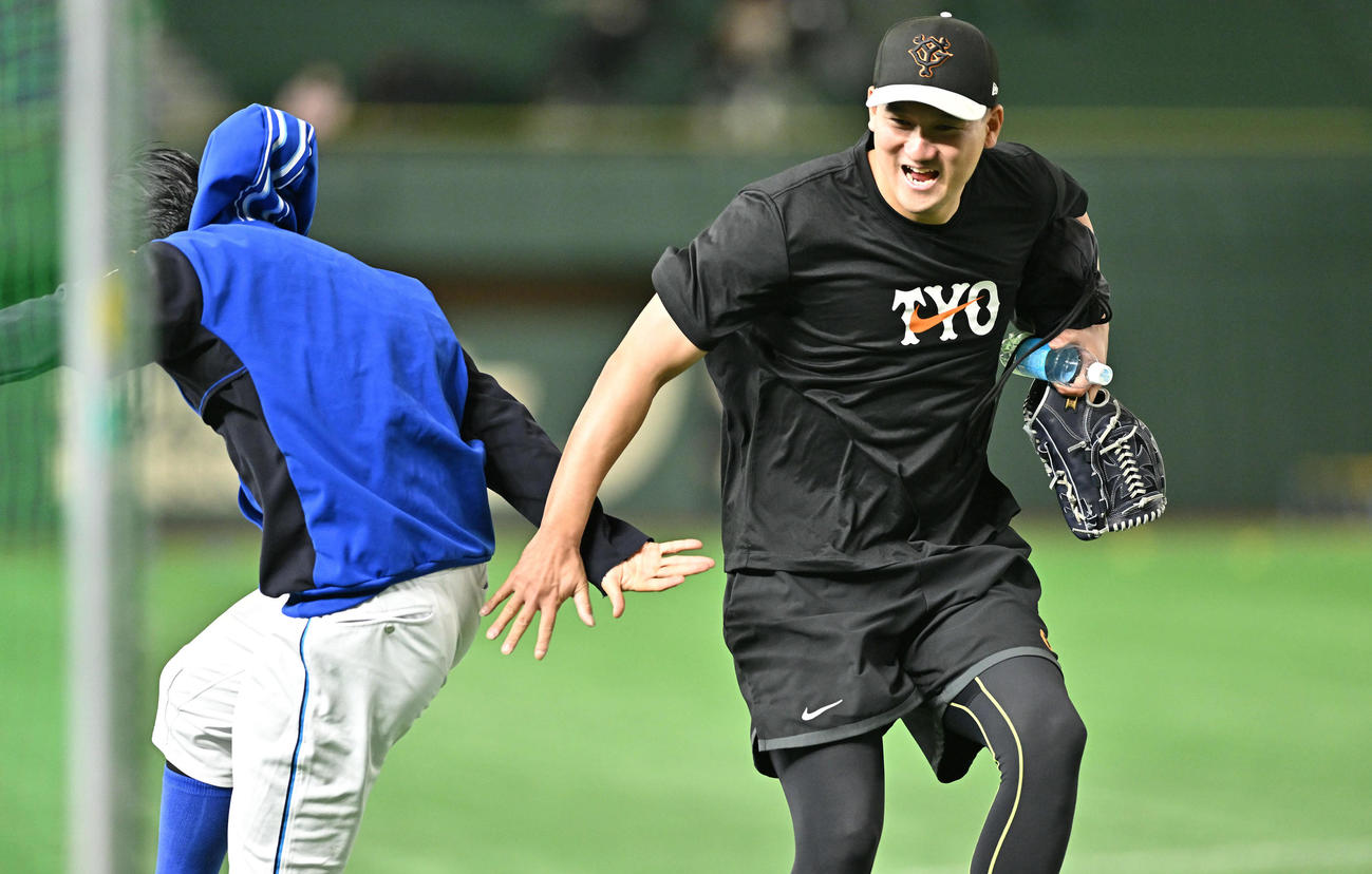 巨人対DeNA　試合前練習でジャンプしてタッチをかわす巨人三上（右）とDeNA関根（撮影・滝沢徹郎）